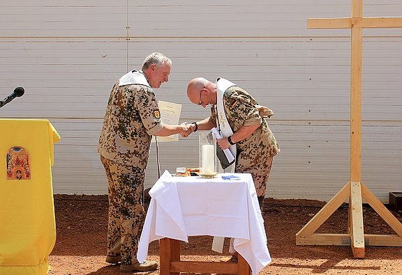 Der Leitende Militärdekan Msgr. Joachim Simon gratuliert Militärpfarrer Andreas Bronder in Mali. © Bundeswehr 