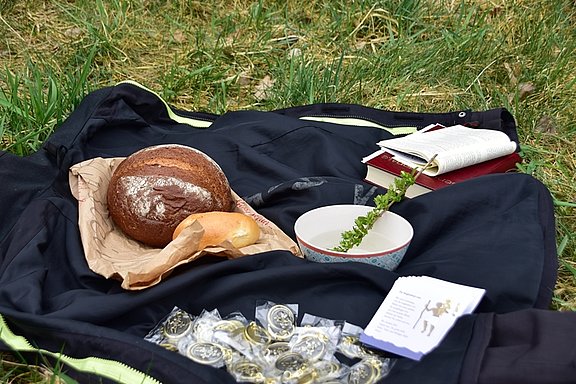 Brot als Zeichen für das letzte Abendmahl Jesu und Christophorus-Plaketten beim Gottesdienst. © KS / Norbert Stäblein