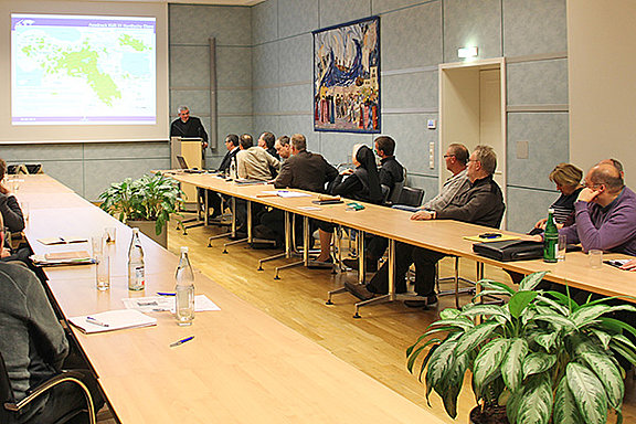 Konzentrierte Teilnehmer im Konferenzsaal der Kurie